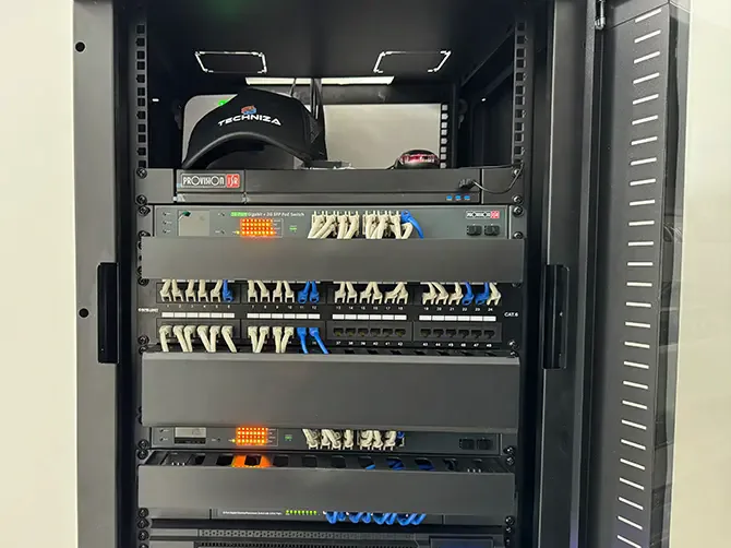 Rack de comunicaciones con patch panels y switch instalado por Techniza