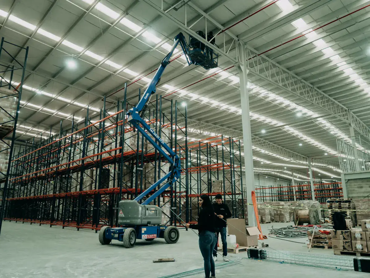 Plataforma elevadora extendida al techo de una nave industrial durante la instalación de cámaras