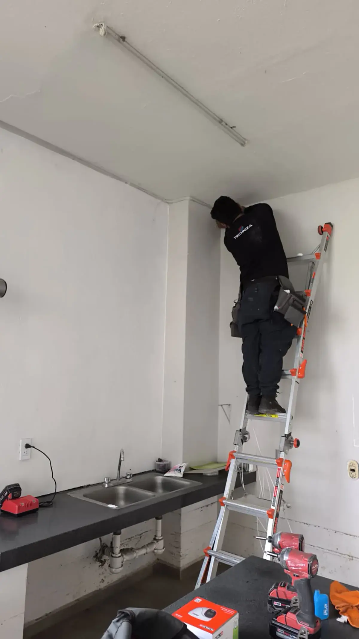 Técnico de Techniza en escalera durante la instalación de un punto de cámara
