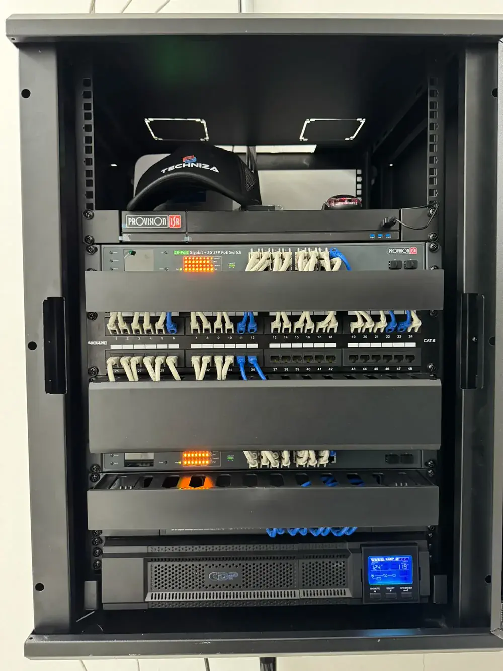 Rack de Techniza con grabador, switch PoE y patch panel CAT6 con el cableado ordenado y etiquetado