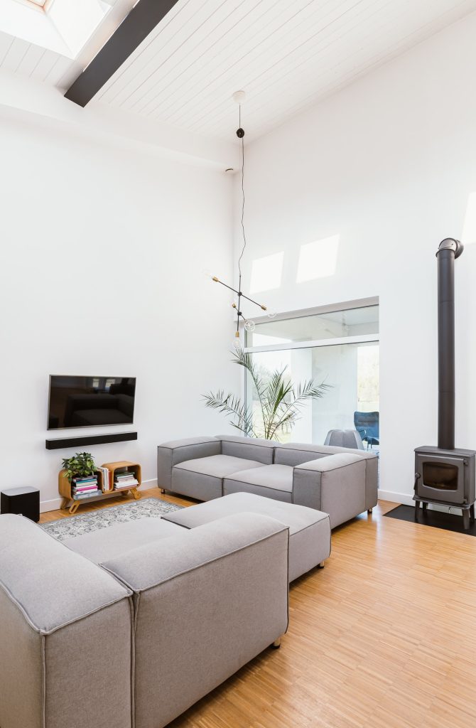 vertical-view-of-elegant-living-room-interior-with-grey-sofa-tv-and-retro-fireplace